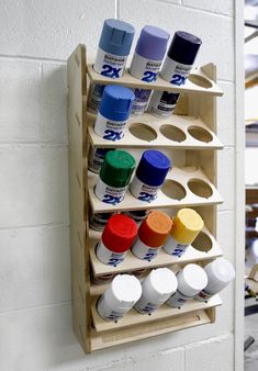 a wall mounted paint rack with several different colors