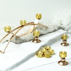 gold candles are sitting on a white blanket