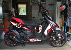 a red and white motorcycle parked in a garage