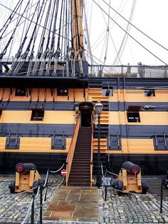 a large yellow and black ship with stairs leading up to it