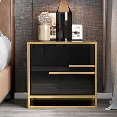 a black and gold nightstand next to a bed