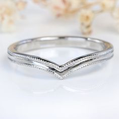 a white gold wedding band with pave set diamonds on the sides and an elegant twist design