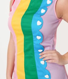 An eye-catching 1960s inspired silhouette crafted in a sturdy woven fabric that features a rainbow striped design on the front. Outfitted with an adorable heart faux button up placket, accented with a chic scallop. Complete with a side zipper and a scalloped hem.Available in sizes XS-4X while supplies last. 70’s Mini Dress, Retrofuture Fashion, 60s Party Outfit, Mini Dress Unique, Futurism Fashion, Rainbow Clothes, Gogo Dress, 1960s Inspired, Dress Unique