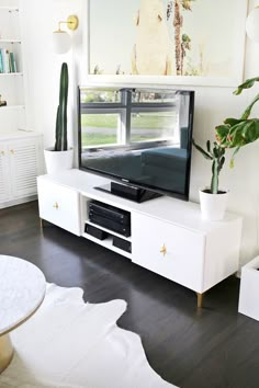 a white entertainment center with a large television on it