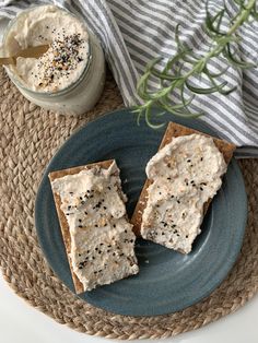 two pieces of crackers sitting on top of a blue plate next to a jar of whipped cream