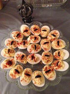 small deviled eggs are arranged on a glass platter