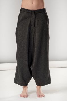 "Structured yet flowing, these black melange wool pants are a match made in heaven: the extremely low drop bottom, the manly back pocket and the side pleat pay homage to both masculine trousers and feminine long skirts to create an year-round wardrobe essential that will win you over with its understated eccentricity and unmatched comfort. We add a final touch to everything you buy from us by wrapping it in our reusable signature black canvas zip bag. Enjoy! Our wonderful model has these measure Gray Wool Trousers, Round Wardrobe, Black Linen Pants, Drop Crotch Pants, Pants Loose, Lovely Tops, Long Skirts, Wool Trousers, Zipped Bag