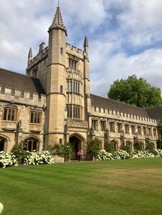 an old building with white flowers on the lawn