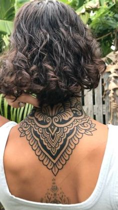 the back of a woman's neck with tattoos on it