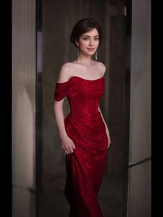 a woman in a red dress posing for the camera