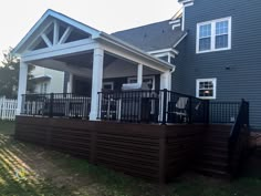 a house with a deck and railings in front of it