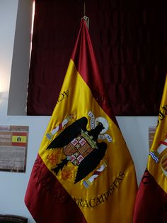 two flags hanging from the side of a wall