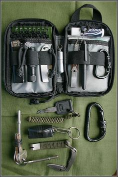 the contents of a tool bag are laid out on a green surface with tools in it