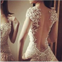 the back of a woman's wedding dress with pink roses and hearts on it