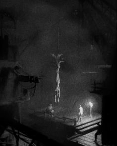 a man standing on top of a wooden floor next to a cross in the dark