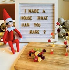 an elf is sitting in front of a sign that says i made a house that can you make?