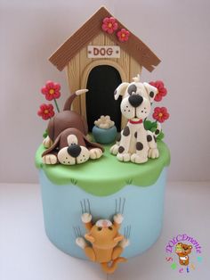 there is a cake that has dogs on it and a doghouse in the background