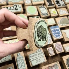 a person is holding a rubber stamp with an image of a bear on it in front of hundreds of stamps