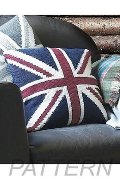 a black chair with two pillows on it and a cat sitting next to the pillow