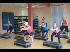 a group of people doing exercises on treadmills in a room with exercise mats