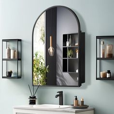 a bathroom with a sink, mirror and shelves on the wall next to each other