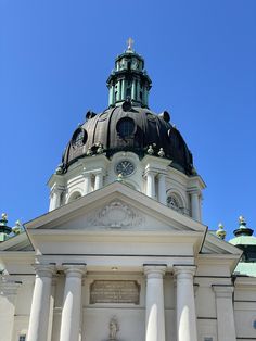 a large white building with a clock on it's top and columns around it