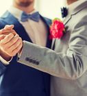 two men in suits and bow ties are holding each other's hands with one another