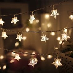 some white lights are hanging from a string with stars on them in the dark room