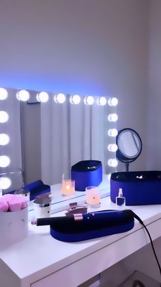 a white desk topped with a vanity mirror and lots of lights on top of it