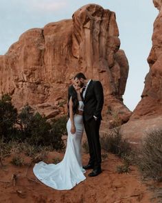 a bride and groom pose for a photo in front of the rocks at valley of fire