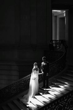 the bride and groom are walking down the stairs at their wedding reception in black and white