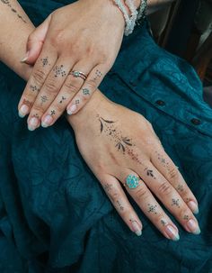 two women with matching tattoos on their hands, one holding the other's hand