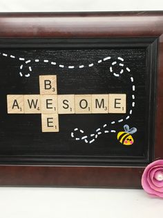 a crossword puzzle with the words be awesome and bee on it next to a pink flower