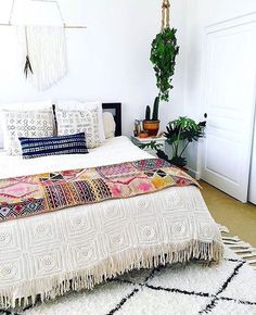 an instagram photo of a bed in a room with plants and potted plants