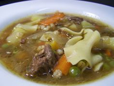 a white bowl filled with soup and noodles