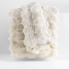 a white blanket is folded on top of each other and it's been made out of sheep fur