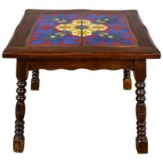 an old wooden table with colorful tiles on it