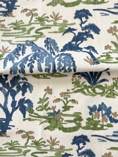 the fabric is blue and green with trees on it