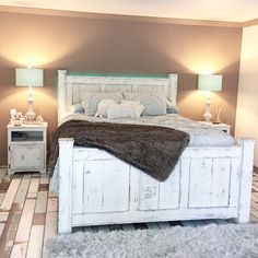 a white bed sitting in a bedroom next to two nightstands with lamps on them