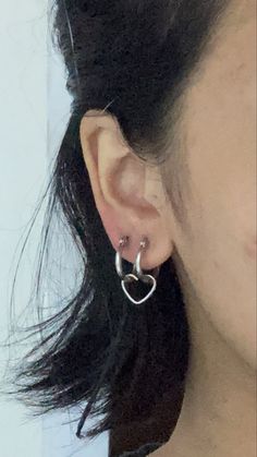 a close up of a person wearing some kind of silver earring on their left ear