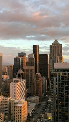 the city is full of tall buildings under a cloudy sky