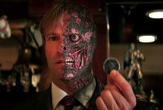 a man in a suit and tie holding up a knife to the camera with a creepy mask on his face