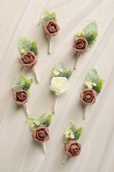 six boutonnieres are arranged in the shape of roses