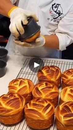 the baker is decorating pastries with golden swirl designs on them and holding a cupcake