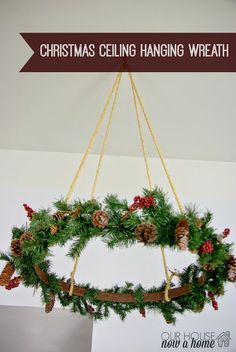 a christmas wreath hanging from the ceiling with pine cones and evergreens on it's branches