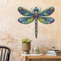 a colorful dragonfly sitting on top of a wooden table