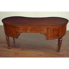 an oval shaped desk with two drawers on one end and three legs on the other