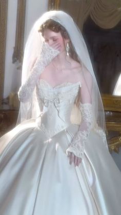 a woman in a wedding dress is posing for the camera with her hand on her face