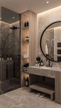 a bathroom with marble walls and flooring has a large round mirror above the sink