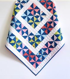 a blue and pink patchwork quilt on top of a white table